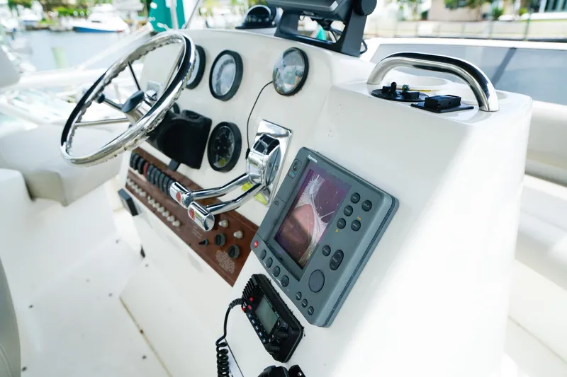 Slide: The Image of 2002 Silverton 352 Motor Yacht helm with steering wheel and navigation instruments. - 14