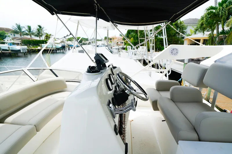 Slide: The Image of 2002 Silverton 352 Motor Yacht interior with helm, seating, and marina view. - 19