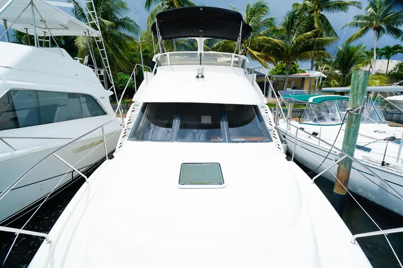 Slide: The Image of 2002 Silverton 352 Motor Yacht docked among palm trees and neighboring boats. - 25