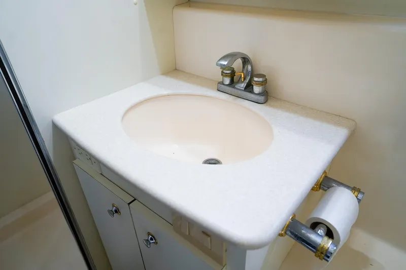 Slide: The Image of 2002 Silverton 352 Motor Yacht bathroom sink with faucet and storage cabinet. - 30