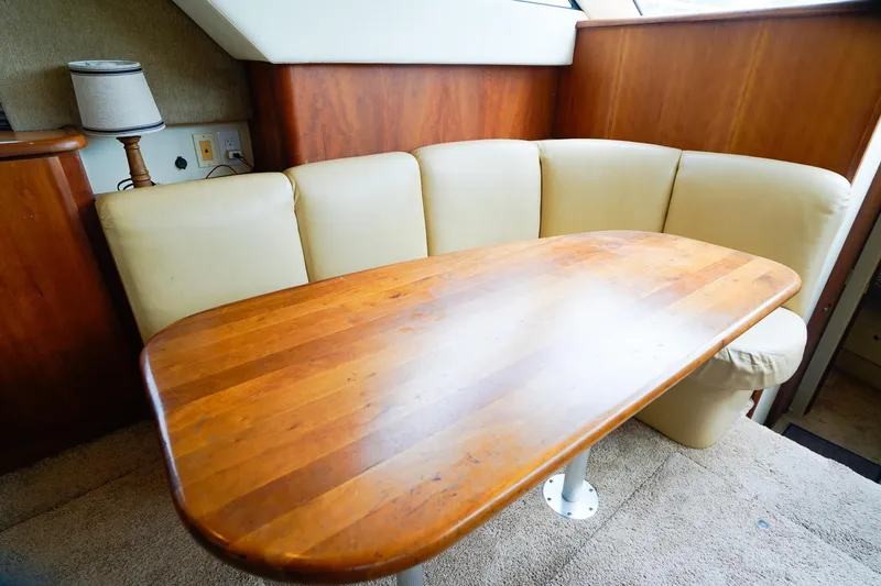 Slide: The Image of Interior of 2002 Silverton 352 Motor Yacht with wooden table and beige seating. - 37