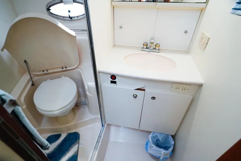 Slide: The Image of 2002 Silverton 352 Motor Yacht bathroom with toilet, sink, and mirror cabinet. - 40