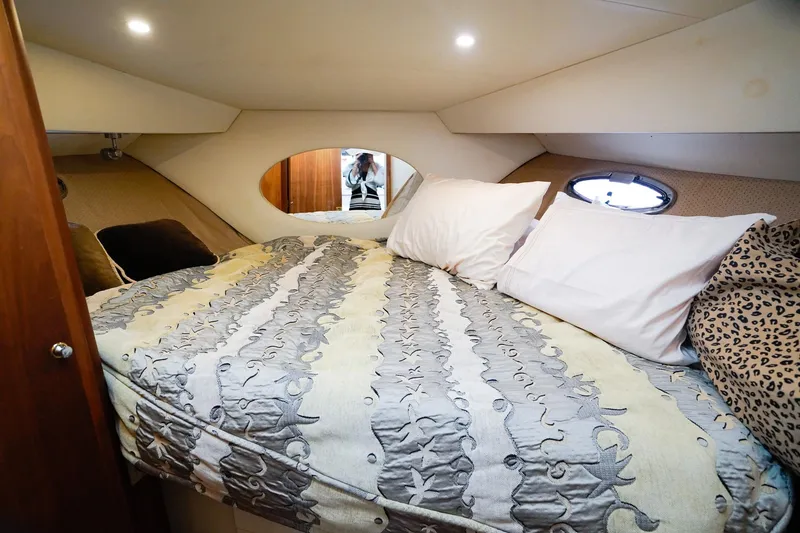 Slide: The Image of Cozy bedroom in 2002 Silverton 352 Motor Yacht with patterned bedding and porthole window. - 43