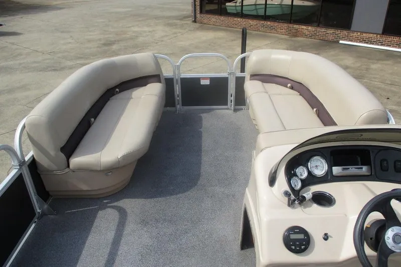 Slide: The Image of 2018 Sun Tracker Party Barge 18 DLX interior with beige seating and control panel. - 7