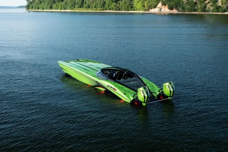 The Image of 2025 MTI 440X powerboat in vibrant green on a trailer outside a garage. - 0