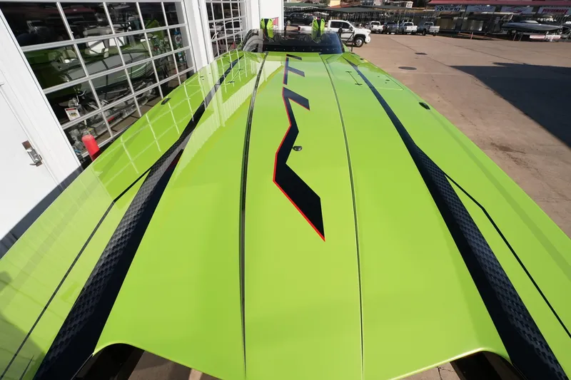 Slide: The Image of 2025 MTI 440X powerboat with vibrant green and black design, parked outdoors. - 16