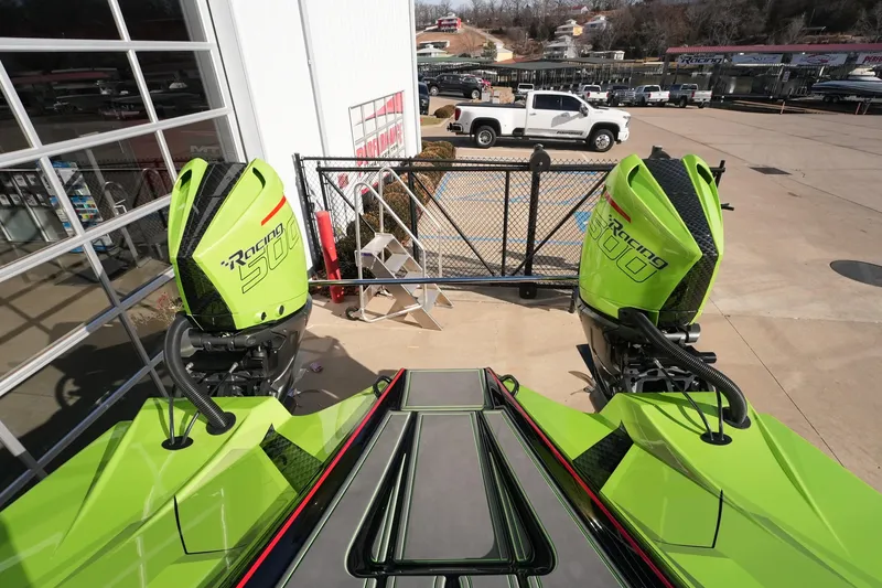 Slide: The Image of Green MTI 440X boat with dual Racing 500 engines, parked outside a showroom. - 17