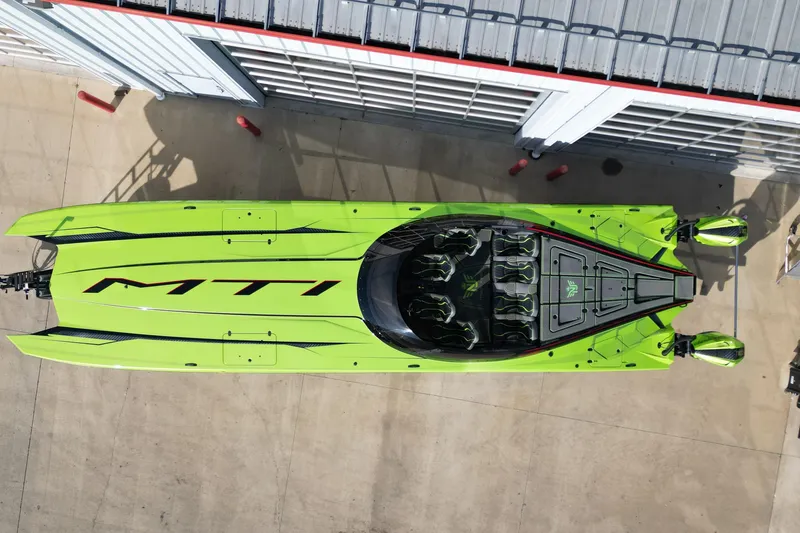 Slide: The Image of Aerial view of 2025 MTI 440X speedboat in vibrant green, docked beside a building. - 24