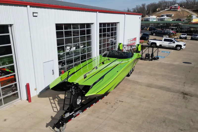 Slide: The Image of Bright green 2025 MTI 440X powerboat on trailer outside a garage. - 28