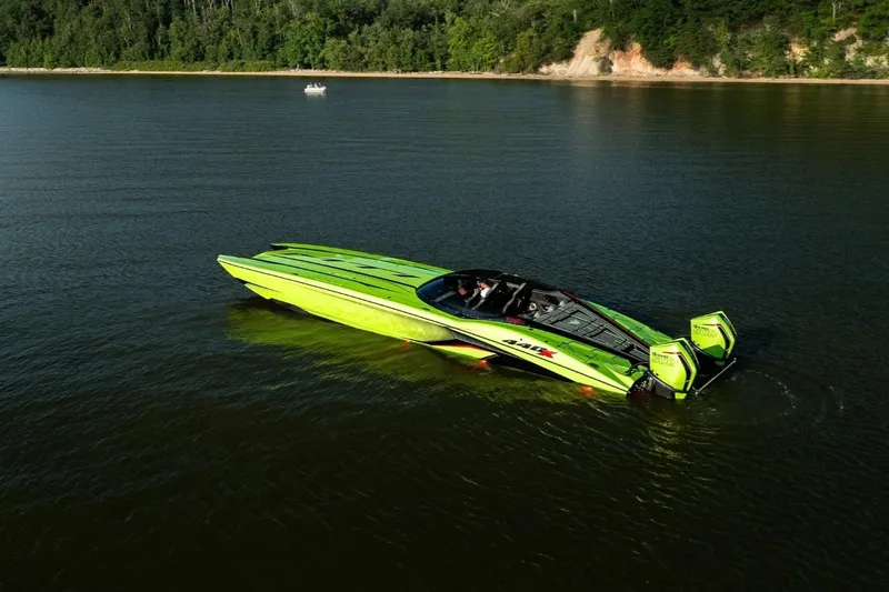 Slide: The Image of 2025 MTI 440X powerboat in vibrant green on trailer outside a garage. - 6