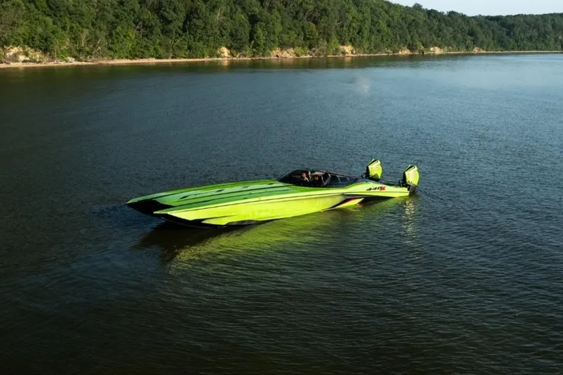Slide: The Image of Aerial view of a vibrant green 2025 MTI 440X speedboat parked outside a garage. - 7