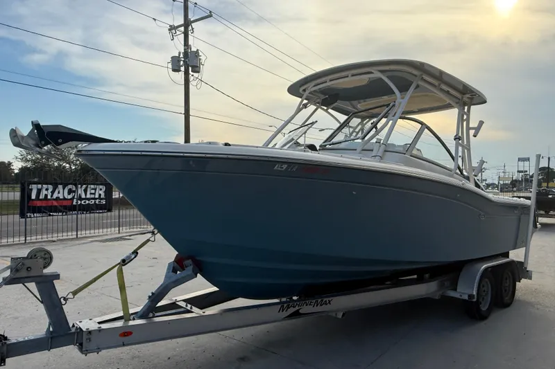 Slide: The Image of 2019 Grady-White Freedom 235 boat on trailer at sunset, parked near Tracker Boats sign. - 3