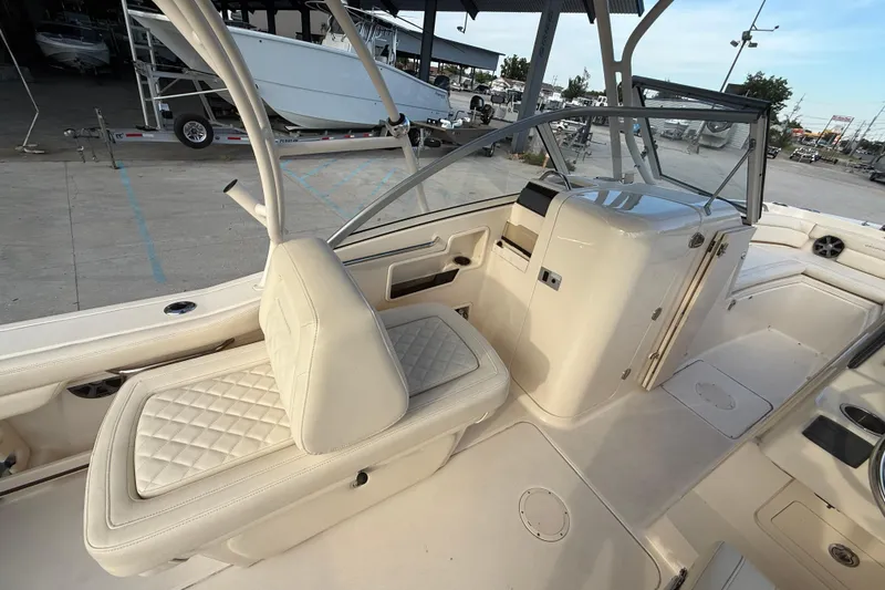 Slide: The Image of 2019 Grady-White Freedom 235 boat interior with cushioned seating and helm station. - 9