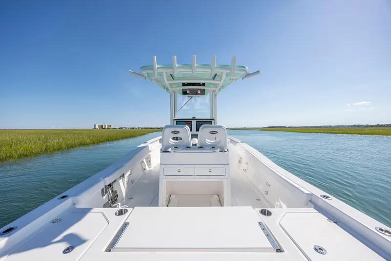 Slide: The Image of 2026 Caymas 291 HB boat cruising on a serene waterway under clear blue skies. - 13