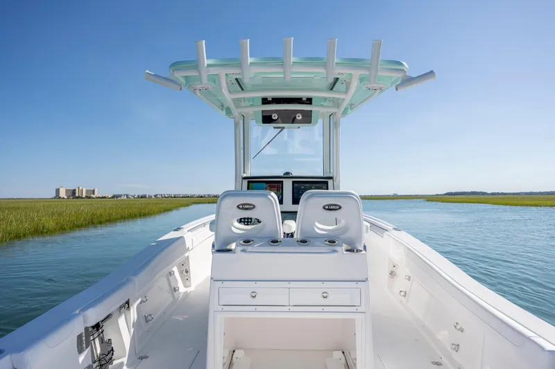 Slide: The Image of 2026 Caymas 291 HB boat navigating a serene waterway under clear blue skies. - 14