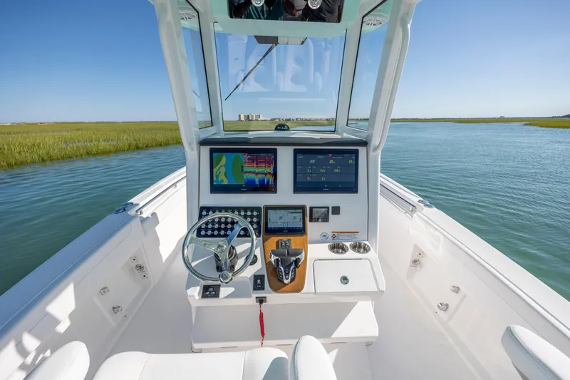 Slide: The Image of 2026 Caymas 291 HB boat cockpit with advanced navigation system on calm water. - 16