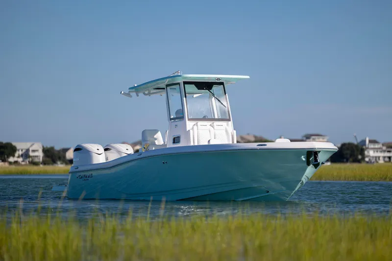 Slide: The Image of 2026 Caymas 291 HB boat on calm water with coastal background. - 2