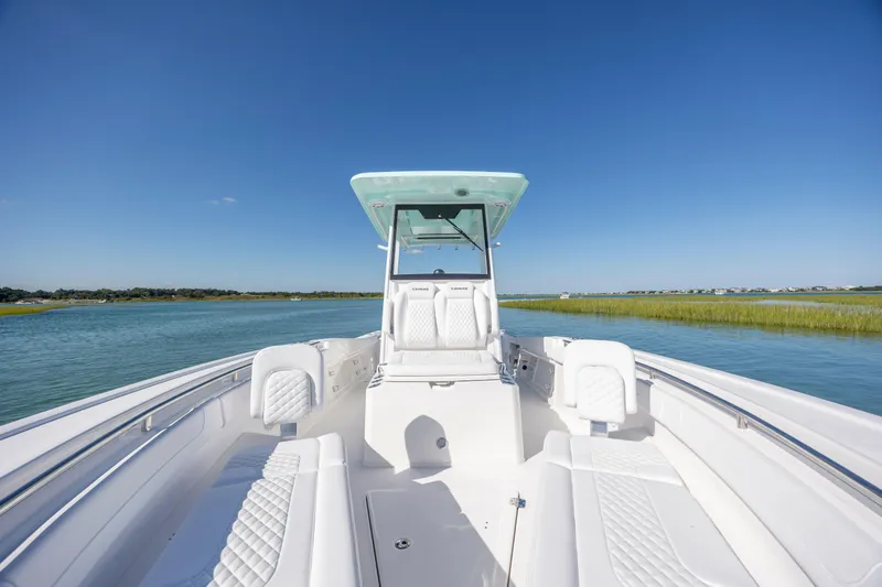 Slide: The Image of 2026 Caymas 291 HB boat on calm water, featuring sleek white seating and clear blue skies. - 20