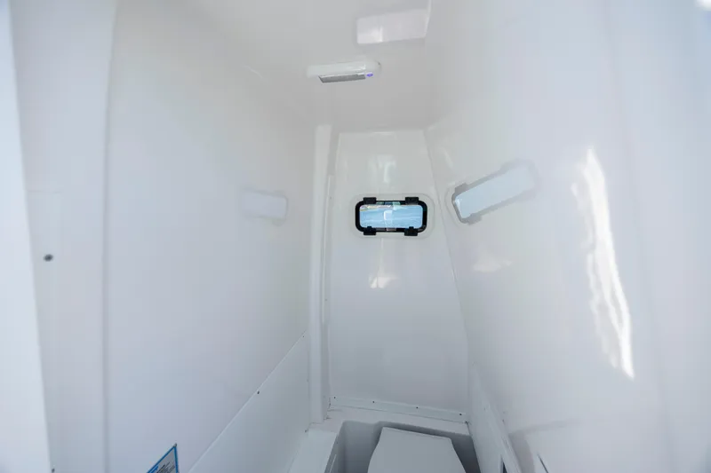 Slide: The Image of Interior cabin of 2026 Caymas 291 HB boat, featuring sleek white design and small window. - 21