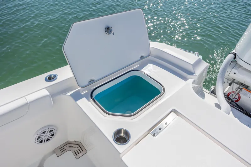 Slide: The Image of 2026 Caymas 291 HB boat with open storage compartment on deck, near water. - 25