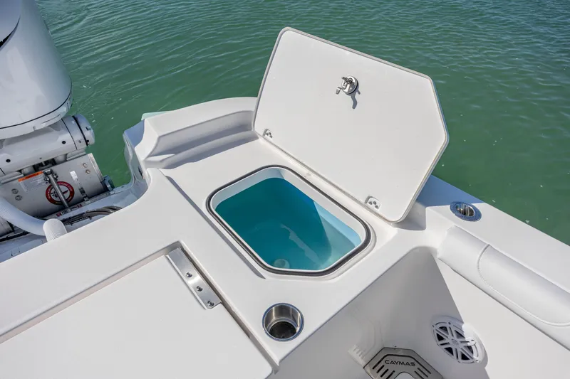 Slide: The Image of 2026 Caymas 291 HB boat with open storage compartment on deck, near water. - 27