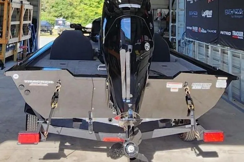 Slide: The Image of 2026 Tracker Pro Team 175 boat in garage, rear view with motor and trailer. - 4