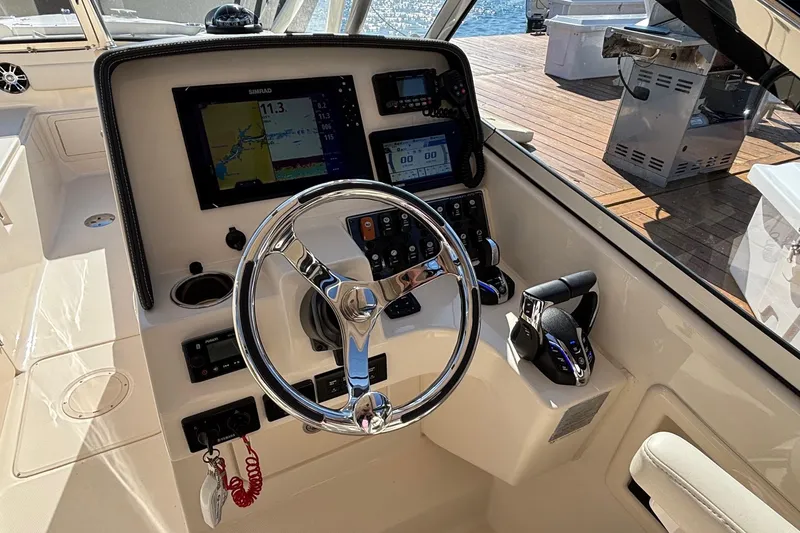 Slide: The Image of 2020 Grady-White Freedom 275 boat helm with steering wheel and navigation controls. - 14