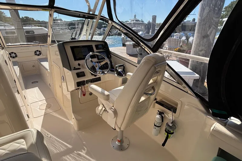 Slide: The Image of 2020 Grady-White Freedom 275 boat interior with steering wheel and dashboard controls. - 16