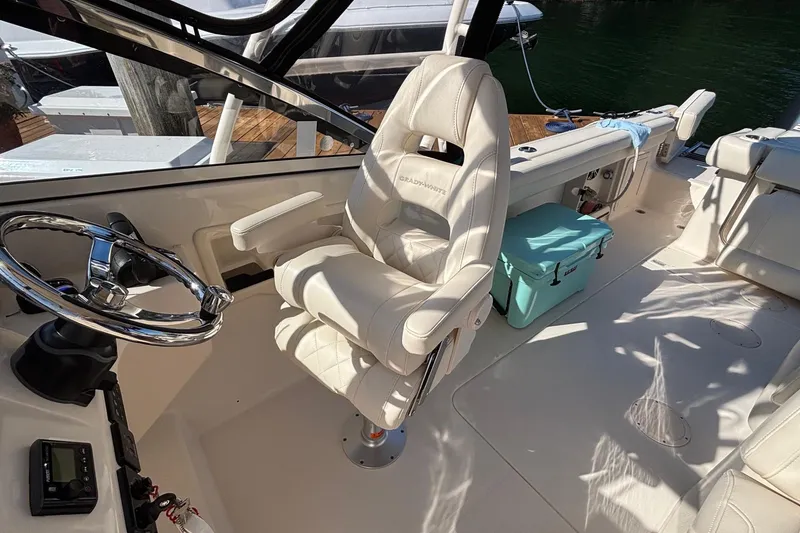Slide: The Image of 2020 Grady-White Freedom 275 boat interior with steering wheel and cushioned seating. - 19