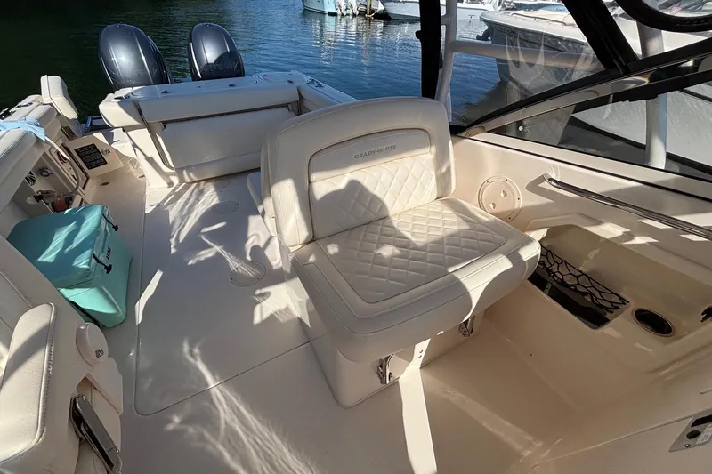 Slide: The Image of 2020 Grady-White Freedom 275 boat interior with cushioned seating and dual outboard motors. - 22