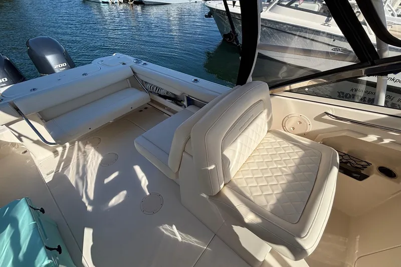 Slide: The Image of 2020 Grady-White Freedom 275 boat interior with cushioned seating and dual engines. - 25