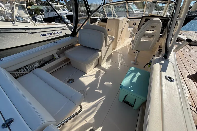 Slide: The Image of 2020 Grady-White Freedom 275 boat interior with seating and helm, docked at marina. - 27
