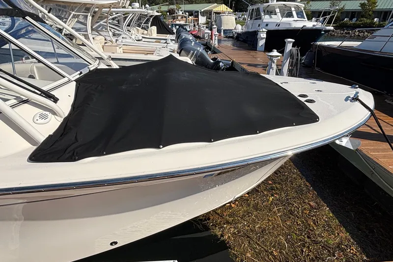 Slide: The Image of 2020 Grady-White Freedom 275 boat docked with black cover, marina background. - 3