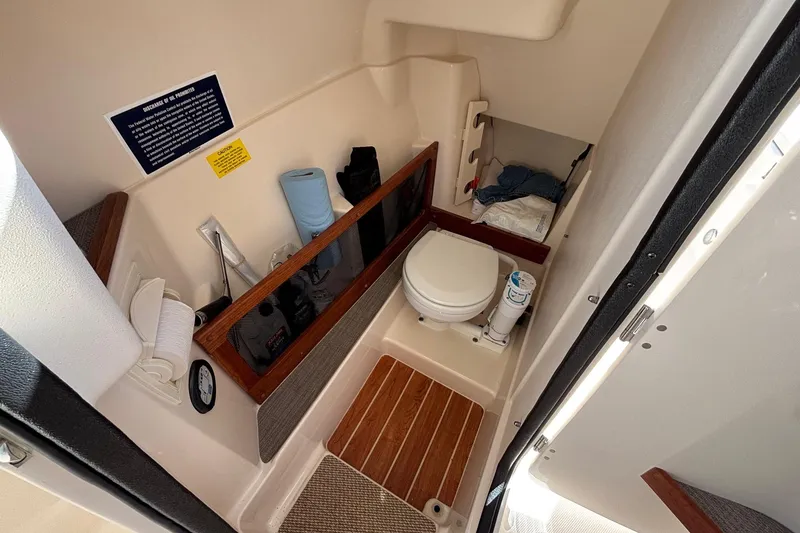 Slide: The Image of 2020 Grady-White Freedom 275 boat interior with compact marine toilet setup. - 31