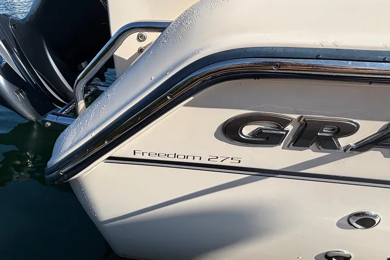 Slide: The Image of 2020 Grady-White Freedom 275 boat stern with chrome details and model name. - 32