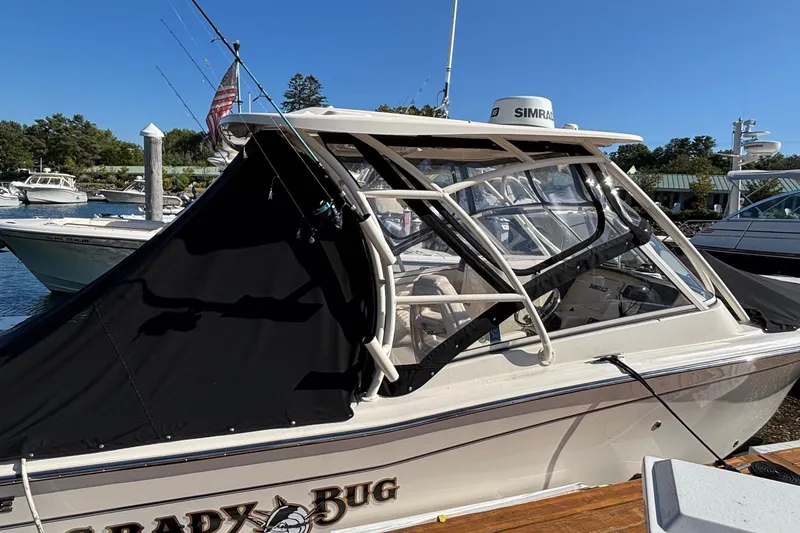 Slide: The Image of 2020 Grady-White Freedom 275 boat docked, featuring enclosed cabin and fishing rods. - 5
