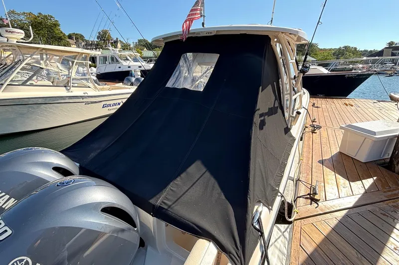 Slide: The Image of 2020 Grady-White Freedom 275 boat docked with black cover and twin Yamaha engines. - 9