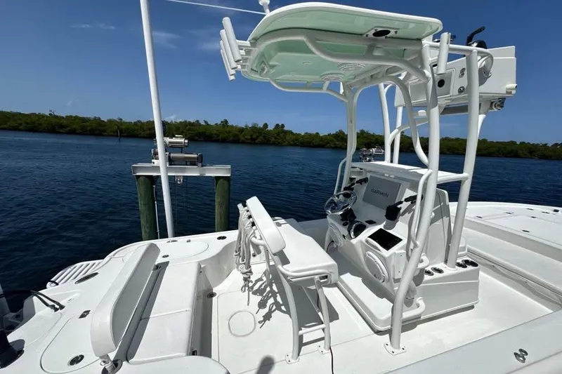 Slide: The Image of 2017 Yellowfin 24 Bay CE boat with advanced navigation system, docked by serene waters. - 13