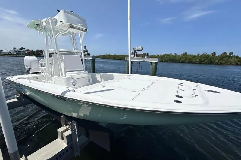 Slide: The Image of 2017 Yellowfin 24 Bay CE boat docked on a lift by the water. - 14