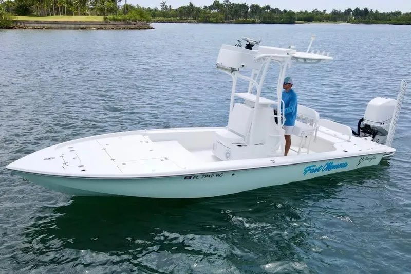 Slide: The Image of 2017 Yellowfin 24 Bay CE boat on calm water with a person at the helm. - 7