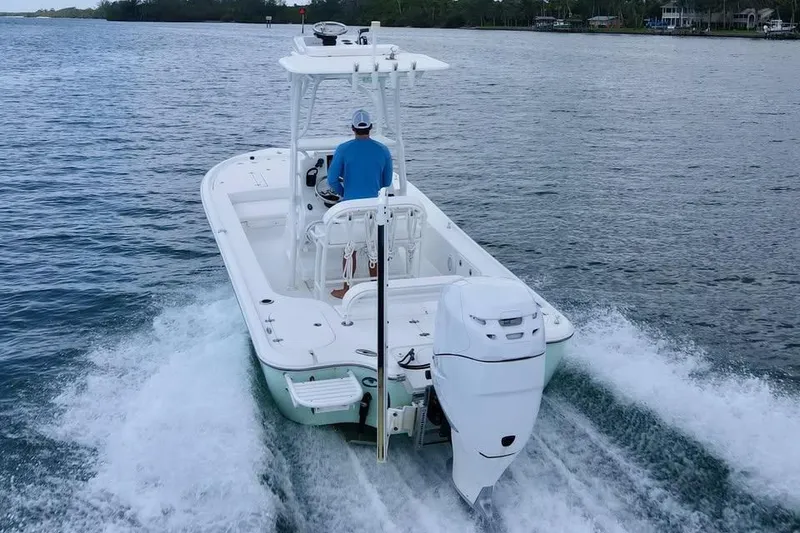 Slide: The Image of 2017 Yellowfin 24 Bay CE boat cruising on open water, rear view. - 8
