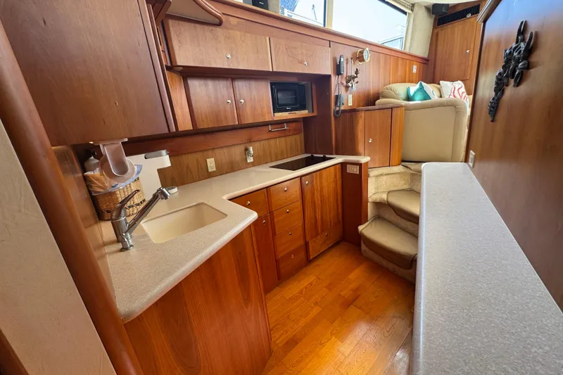 Slide: The Image of 2003 Silverton 42 Convertible yacht interior with wooden cabinetry and modern kitchen amenities. - 10