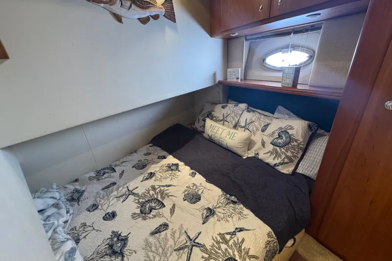 Slide: The Image of Cozy bedroom in 2003 Silverton 42 Convertible yacht with nautical-themed bedding. - 11