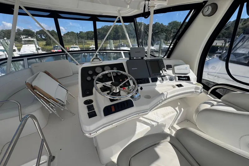 Slide: The Image of 2003 Silverton 42 Convertible yacht helm with modern navigation equipment and comfortable seating. - 19