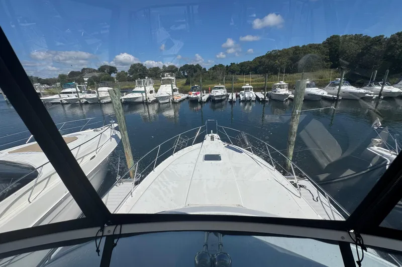 Slide: The Image of 2003 Silverton 42 Convertible yacht docked at marina, surrounded by other boats. - 24
