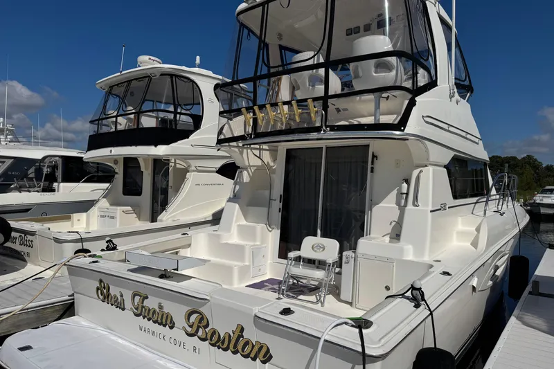 Slide: The Image of 2003 Silverton 42 Convertible yacht docked at marina under clear blue sky. - 3