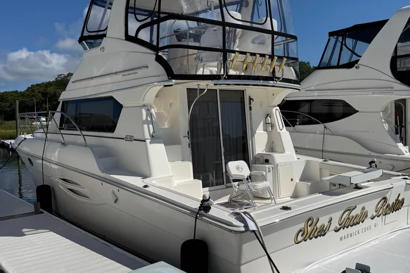 Slide: The Image of 2003 Silverton 42 Convertible yacht docked at marina under clear blue sky. - 4