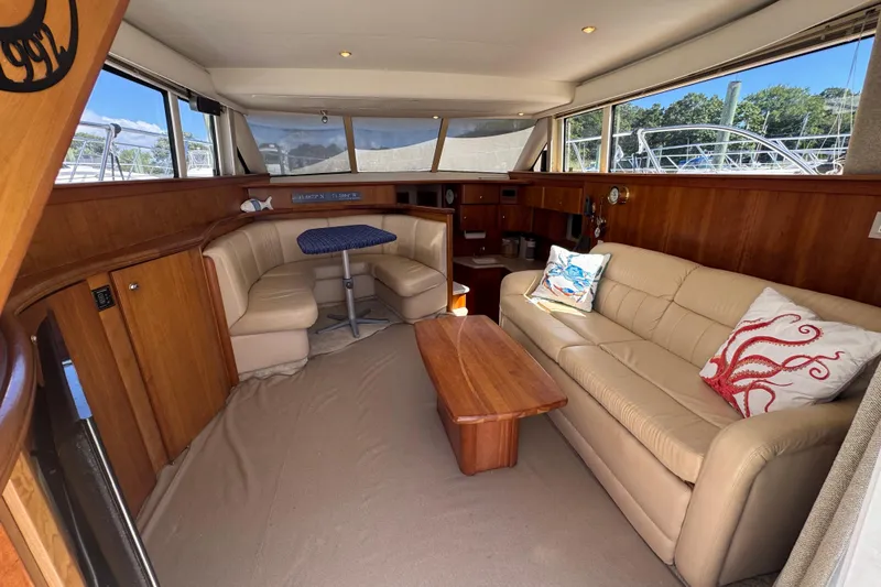 Slide: The Image of Interior of 2003 Silverton 42 Convertible yacht with beige seating and wooden accents. - 7