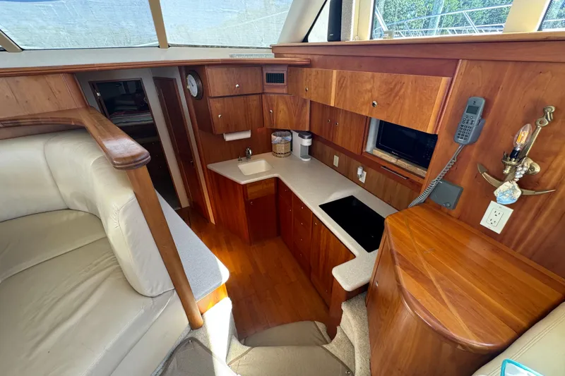 Slide: The Image of 2003 Silverton 42 Convertible yacht interior with wood cabinetry and compact kitchen area. - 8