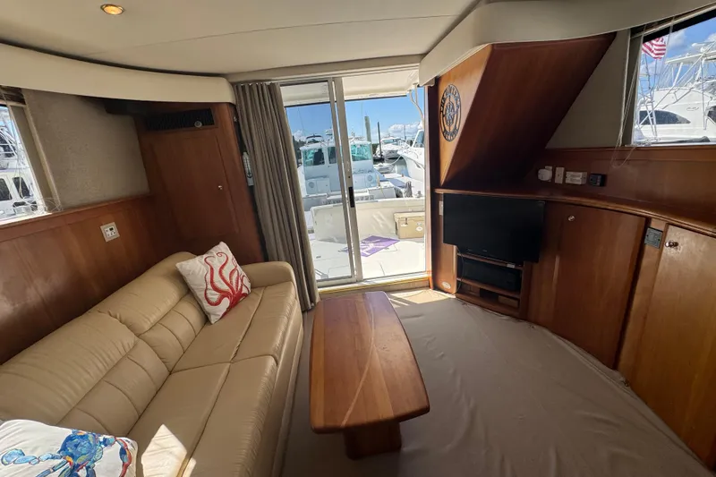 Slide: The Image of Interior of 2003 Silverton 42 Convertible yacht with sofa, TV, and sliding glass door. - 9